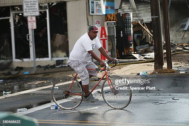 Man rides his bike at the scene of a massive fire that destroyed dozens of businesses along an iconic Jersey shore boardwalk on September 13, 2013 in...