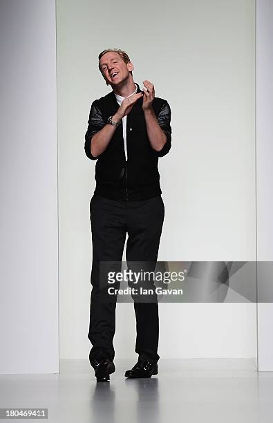 Designer Christopher Raeburn acknowledges the crowd after his show during London Fashion Week SS14 at BFC Courtyard Showspace on September 13, 2013...