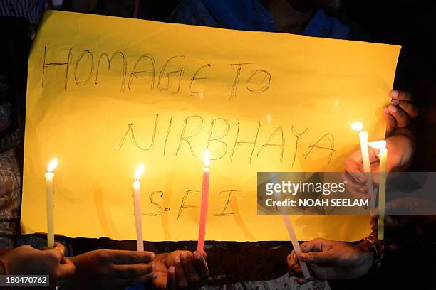 Indian students of Osmania University hold candles and placards following the sentencing in New Delhi of four men convicted of rape and murder,...