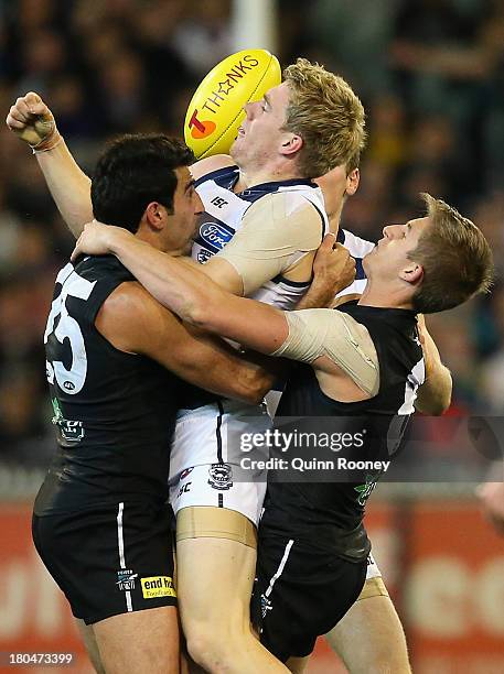 Cameron Guthrie of the Cats is tackled by Domenic Cassisi and Hamish Hartlett of the Power during the Second Semi Final match between the Geelong...