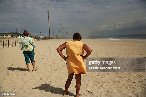 Two women stand near the scene of a massive fire that destroyed dozens of businesses along an iconic Jersey shore boardwalk on September 13, 2013 in...