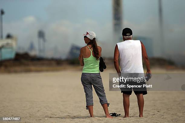 Two people stand near the scene of a massive fire that destroyed dozens of businesses along an iconic Jersey shore boardwalk on September 13, 2013 in...