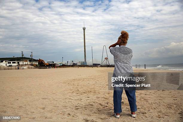 Woman stands near the scene of a massive fire that destroyed dozens of businesses along an iconic Jersey shore boardwalk on September 13, 2013 in...