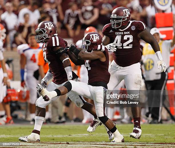 Tommy Sanders of the Texas A&M Aggies alond with Toney Hurd Jr. #4 and Kirby Ennis celebrate after a big defensive stop at Kyle Field on September 7,...