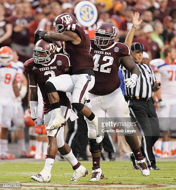 Tommy Sanders of the Texas A&M Aggies alond with Toney Hurd Jr. #4 and Kirby Ennis celebrate after a big defensive stop at Kyle Field on September 7,...