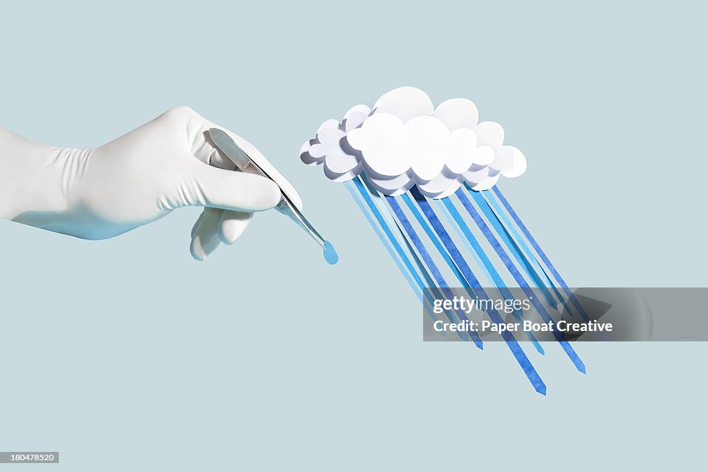 Hand holding a drop of paper craft rain from cloud