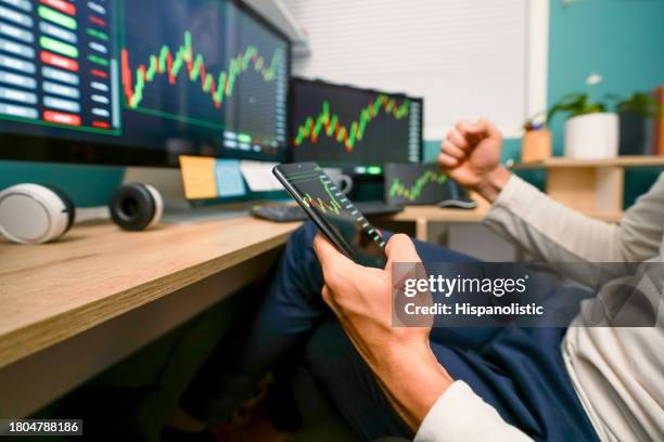 excited man watching the behavior of his investments in the stock market in different devices - bitcoin stock pictures, royalty-free photos & images