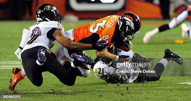 Wes Welker of the Denver Broncos is tackled by Michael Huff of the Baltimore Ravens during the third quarter of the game at Sports Authority Field at...