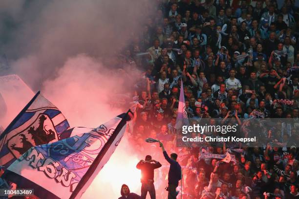 Fans of Muenchen throw smoke bombs during the Second Bundesliga match between VfR Aalen and 1860 Muenchen at Scholz-Arena on September 13, 2013 in...