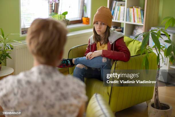 a young woman sitting awkwardly during a counselling meeting - fobia imagens e fotografias de stock