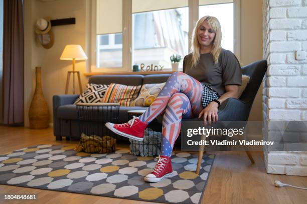 a modern transsexual woman wearing patterned pantyhose sitting in a modern lounge - american flag small stock pictures, royalty-free photos & images