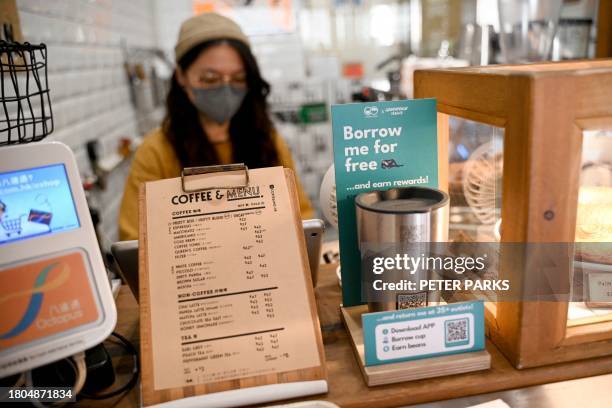 This picture taken on November 2 shows a barista making a coffee in a thermal mug with a QR code at a coffee shop in Hong Kong. The coded mug can be...