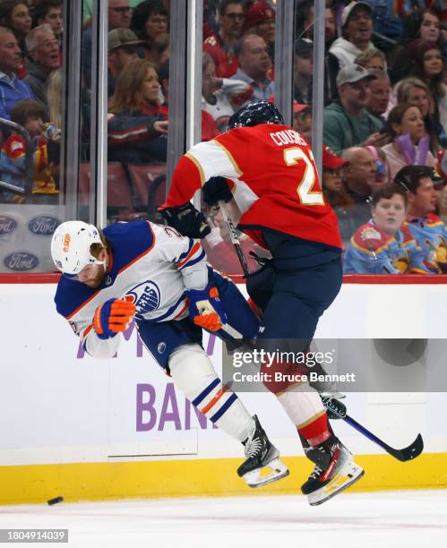 Nick Cousins of the Florida Panthers checks Connor Brown of the Edmonton Oilers during the first period at Amerant Bank Arena on November 20, 2023 in...