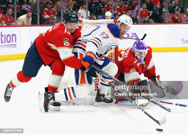 Anton Lundell of the Florida Panthers takes a first period penalty for holding Connor McDavid of the Edmonton Oilers at Amerant Bank Arena on...