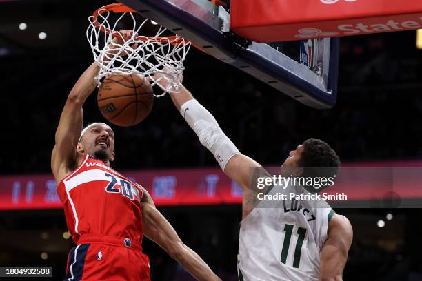 Landry Shamet of the Washington Wizards dunks on Brook Lopez of the Milwaukee Bucks during the first half at Capital One Arena on November 20, 2023...