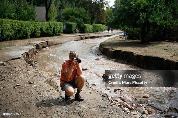 Jake Pommer of Boulder, Colorado takes pictures along what remains of Topaz Street after flooding washed away the street September 13, 2013 in...