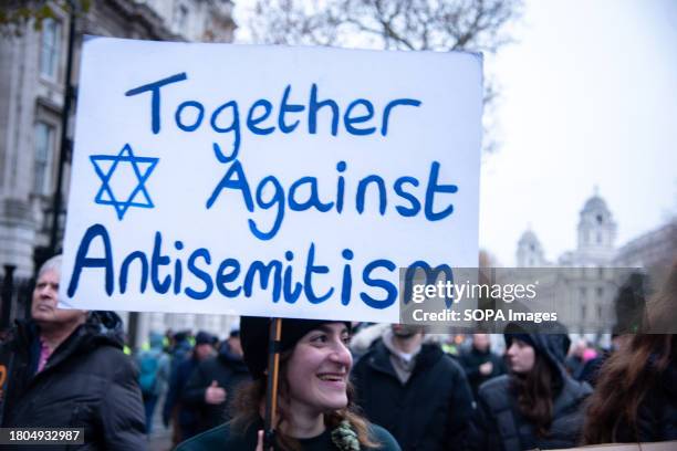Protester holds a placard expressing her opinion during the demonstration march against antisemitism. As antisemitism surges, Britain stands together...
