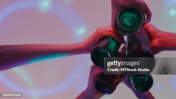 closeup diverse group of friends dancing moving rhythmically in good mood with edm dj at colorful house party at night. multicultural friends having fun together college house party. - beer bottle stock pictures, royalty-free photos & images