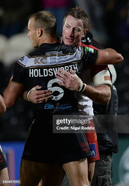 Steve Menzies of Catalan Dragons hugs Daniel Holdsworth of Hull FC after the Super League Play Off between Hull FC and Catalan Dragons at the KC...