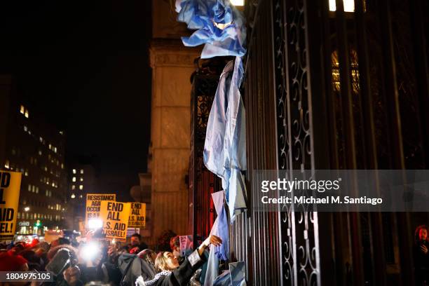 People place their caps and gowns on the gates of Columbia University as they gather to protest the banning of Students for Justice in Palestine and...