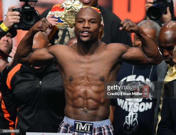 Boxer Floyd Mayweather Jr. Poses on the scale during the official weigh-in for his bout against Canelo Alvarez at the MGM Grand Garden Arena on...