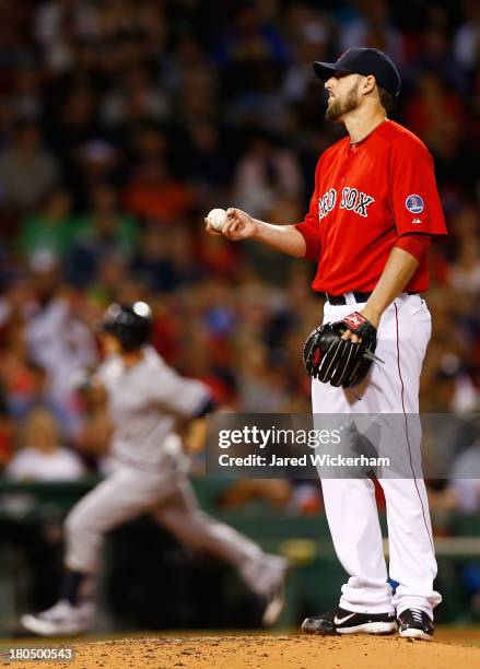 John Lackey of the Boston Red Sox reacts after giving up a home run to Brendan Ryan of the New York Yankees in the third inning during the game on...