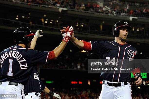 Bryce Harper of the Washington Nationals celebrates wtih Stephen Lombardozzi after scoring on a two-run RBI single off the bat of Wilson Ramos in the...