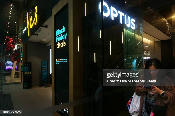 Pedestrian uses a mobile phone outside an Optus store in the CBD on November 21, 2023 in Sydney, Australia. Optus' CEO Kelly Bayer Rosmarin stepped...