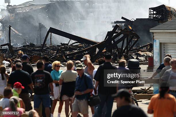 People walk near the scene of a massive fire that destroyed dozens of businesses along an iconic Jersey shore boardwalk on September 13, 2013 in...