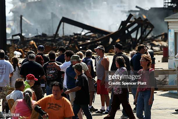People walk near the scene of a massive fire that destroyed dozens of businesses along an iconic Jersey shore boardwalk on September 13, 2013 in...