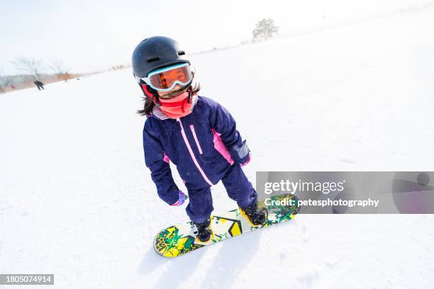 young girl snowboarding for the first time - ski-wear stock pictures, royalty-free photos & images