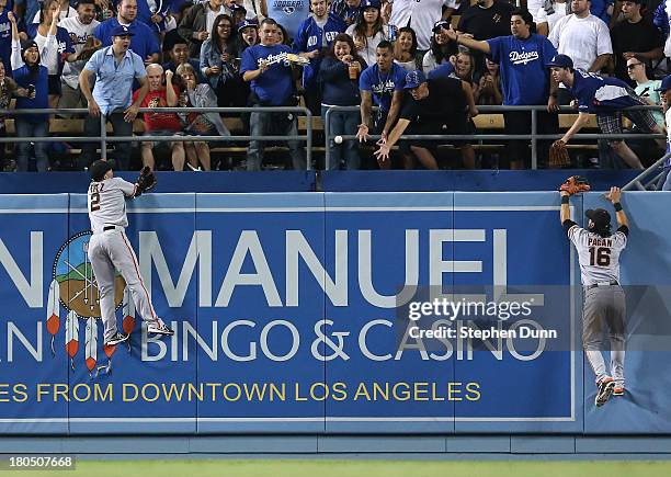 Left fielder Juan Perez and center fielder Angel Pagan of the San Francisco Giants and fans in the left field bleachers can't reach a ball hit by...