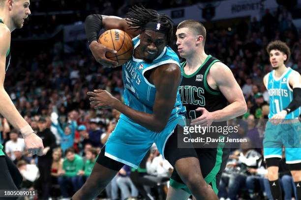 Mark Williams of the Charlotte Hornets and Payton Pritchard of the Boston Celtics fight for a rebound during the second half of an NBA game at...