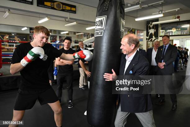 Prince Edward, Duke of Edinburgh, holds the punching bag during boxing with 21 year old Marlon Sevehon from the Youth Boxing Program at the Police...