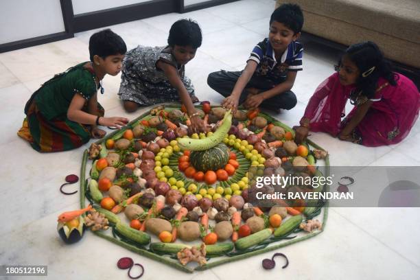 Indian children look at a "pookalam" or floral art made from vegetables during a contest in New Delhi on September 14 ahead of the Onam festival. The...