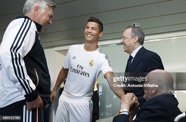 Cristiano Ronaldo of Real Madrid greets Honorary President Alfredo di Stefano alongside head coach Carlo Ancelotti and President Florentino Perez...