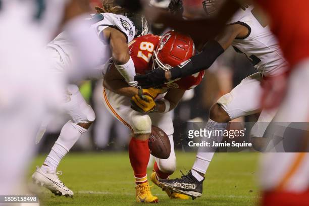 Travis Kelce of the Kansas City Chiefs fumbles the ball after being hit by Bradley Roby and Zach Cunningham of the Philadelphia Eagles in the second...