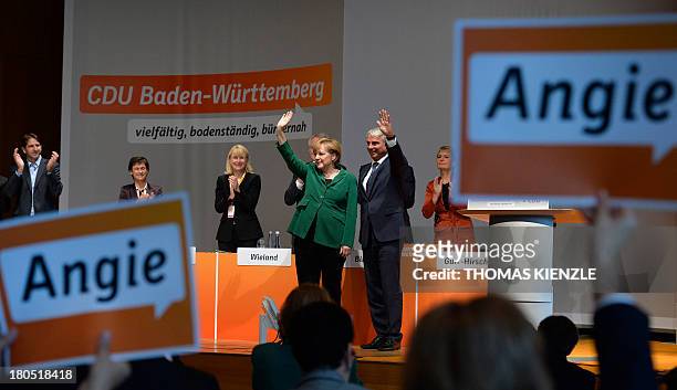 German Chancellor Angela Merkel and regional party chairman Thomas Strobl wave to supporters during a regional convention of their Christian...
