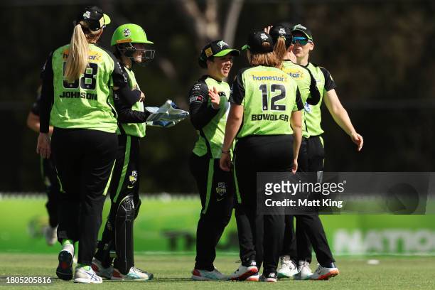 Lauren Smith of the Thunder celebrates with team mates after taking the wicket of Danielle Gibson of the Strikers during the WBBL match between...
