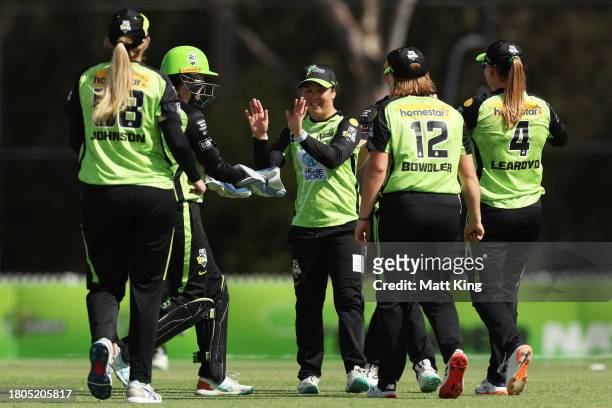 Lauren Smith of the Thunder celebrates with team mates after taking the wicket of Danielle Gibson of the Strikers during the WBBL match between...