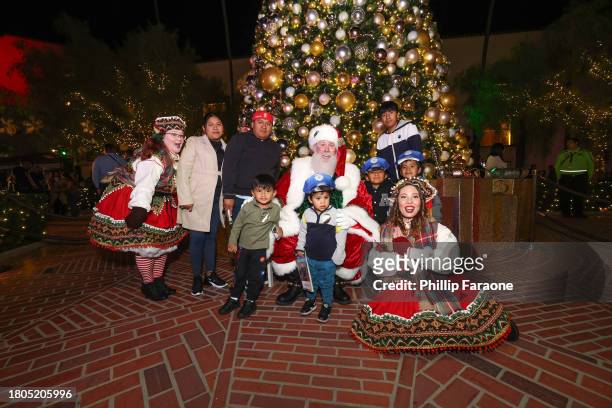 Santa and his Elves pose with a family during the Los Angeles Union Station Tree Lighting Ceremony at Union Station on November 20, 2023 in Los...