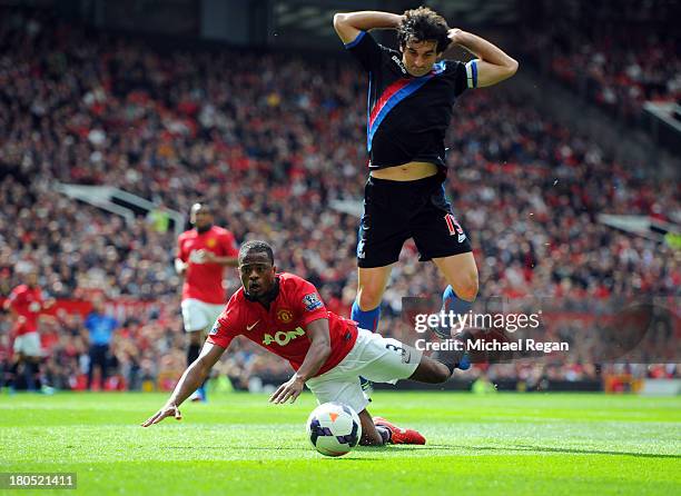 Patrice Evra of Manchester United goes to ground under a challenge by Mile Jedinak of Crystal Palace during the Barclays Premier League match between...