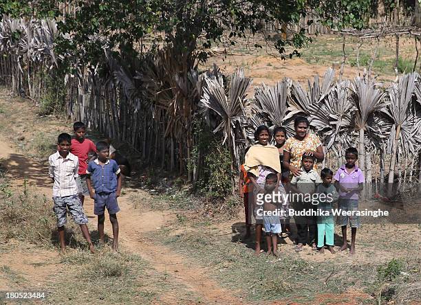 Sri Lankan ethnic Tamil people look on as the President President Mahinda Rajapaksa travels on board a train en route to the former rebel capital of...