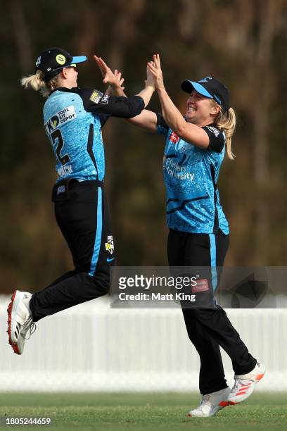 Jemma Barsby of the Strikers celebrates with team mates after taking the wicket of Chamara Athapaththu of the Thunder during the WBBL match between...