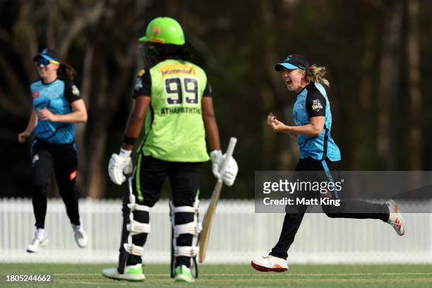Jemma Barsby of the Strikers celebrates with team mates after taking the wicket of Chamara Athapaththu of the Thunder during the WBBL match between...