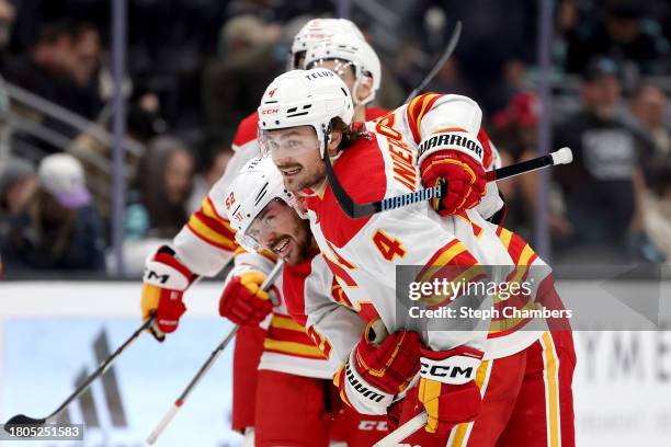 Rasmus Andersson of the Calgary Flames celebrates his game-winning goal in overtime with MacKenzie Weegar of the Calgary Flames against the Seattle...
