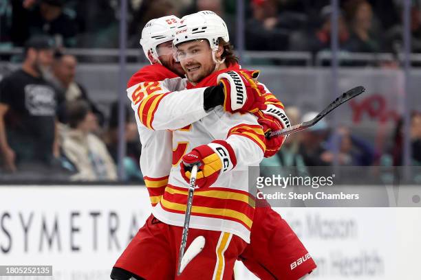 Rasmus Andersson of the Calgary Flames celebrates his game-winning goal in overtime with MacKenzie Weegar of the Calgary Flames against the Seattle...