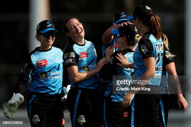 Meghan Schutt of the Strikers celebrates with team mates after taking the wicket of Phoebe Litchfield of the Thunder during the WBBL match between...