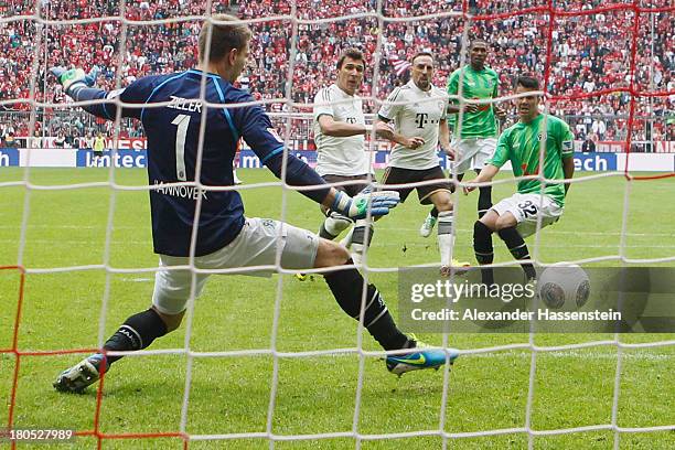 Mario Mandzukic of Muenchen scores the opening goal against Leonardo Bittencourt of Hannover and his keeper Ron-Robert Zieler during the Bundesliga...