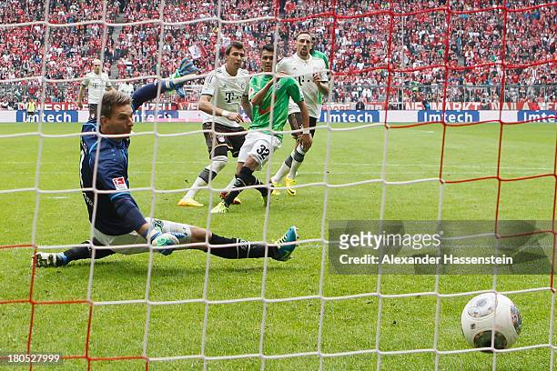 Mario Mandzukic of Muenchen scores the opening goal against Leonardo Bittencourt of Hannover and his keeper Ron-Robert Zieler during the Bundesliga...